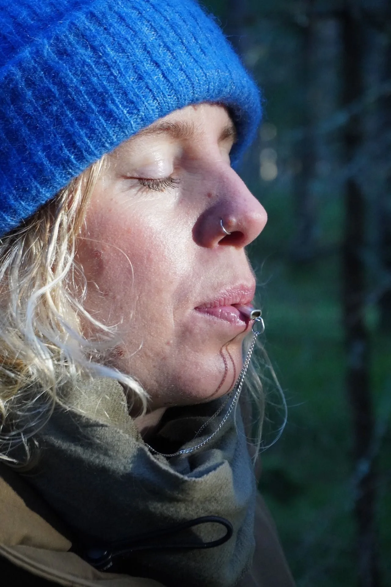A person using the Breathing Jewel pendant outdoors in a Nordic forest